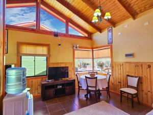 a living room with a table and a tv at Lodge Ancar Atacama in San Pedro de Atacama