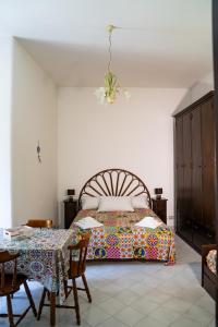 1 dormitorio con 1 cama y 1 mesa con sillas en NIMA Holidays Home, en Canneto