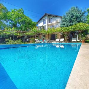 a swimming pool in front of a house at Villa Regina Serafina in Balchik