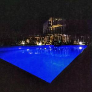 a swimming pool at night with a city in the background at Villa Regina Serafina in Balchik