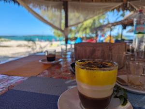 un drink su un piatto su un tavolo vicino alla spiaggia di Ocean Lodge Kite & Windsurf a Antsiranana