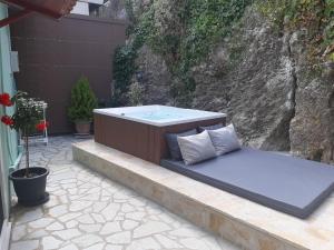 een hot tub op een patio met 2 kussens bij Paraskevi's Luxury Studios in Parga