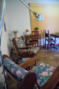 uma sala de estar com várias cadeiras e uma mesa em Casetta dei Nonni em Vitorchiano
