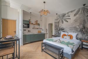 a bedroom with a large bed and a kitchen at Le Félix Appart'Hotel, centre ville Romans-sur-Isère in Romans-sur-Isère