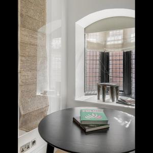 een tafel met een boek voor een spiegel bij Luxury Suite in Cadogan Square II in Londen