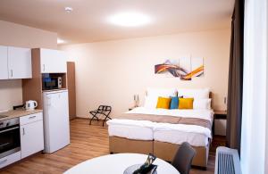 a hotel room with a bed and a kitchen at Elixír Panzió in Nyírbátor