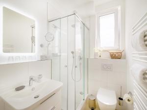 a white bathroom with a shower and a sink at FLAIR Homes - Design Apartments with Smart-TV, Self Check-in & Free Parking in Karlsruhe +11 photos