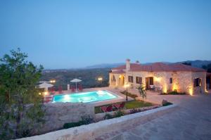 a villa with a swimming pool at night at Dream Hill Villas in Tavronitis +40 photos