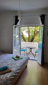 - une chambre avec un lit et une terrasse avec une table dans l'établissement Apartman Padova, à Rab