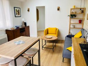 a small living room with a table and chairs at Joli F2 avec terrasse 150m plage in Saint-Aubin-sur-Mer