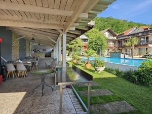a patio with a table and chairs and a pool at Casa Wanted Orsova in Orşova