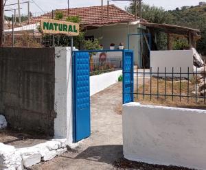 a blue gate in front of a building at Natural Hostel in Himare