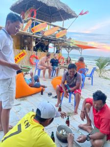 a group of people sitting on the beach at Mui Ne Garden Hotel and Kite School in Mui Ne