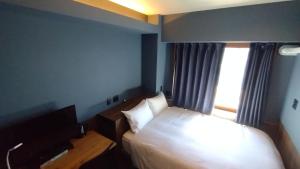 Rúm í herbergi á Handa Station Hotel