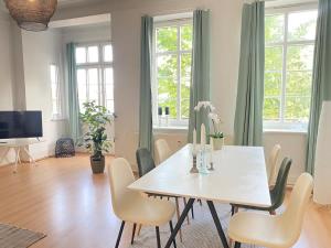 a dining room with a white table and chairs at Boutique lejlighed Nakskov in Nakskov