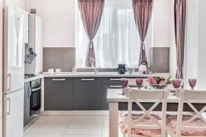 uma cozinha com armários roxos e uma mesa com cadeiras em ARI Rose Apartment in complexul Ared Kaufland em Arad