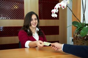 a woman sitting at a table handing a person a piece of money at Solar de Alqueva in Reguengos de Monsaraz