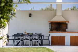 a patio with a table and chairs and a fireplace at Angeliana Villa in Angeliana