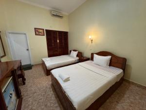 Kampong ChhnangにあるSamrongsen Hotelのベッド2台とテレビが備わるホテルルームです。