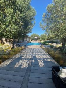 une allée avec des arbres et une piscine dans un parc dans l'établissement Casa Felicia, à Bonifacio
