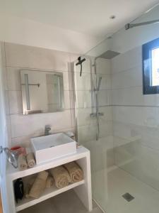 une salle de bain blanche avec un lavabo et une douche dans l'établissement Casa Felicia, à Bonifacio 31 autres photos