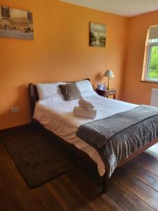 a bedroom with a bed with two towels on it at The Barn Lodge in Tullamore