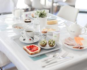 - une table avec un plateau de nourriture et des tasses de café dans l'établissement Hôtel Lapeyronie, à Montpellier