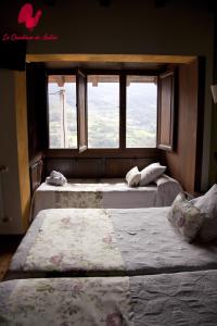 2 camas en una habitación con ventana en La Quintana De Anton, en Jomezana