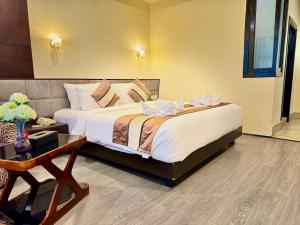 um quarto com uma cama grande e uma mesa em Staynest Tara with mountain valley view near MALL ROAD em Gangtok