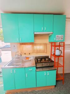 Una cocina azul con fregadero y estufa. en Naru Hostel Korea, en Seúl