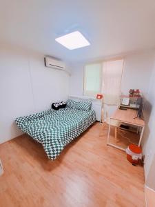 Un dormitorio con una cama y una mesa. en Naru Hostel Korea, en Seúl