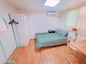 Habitación con cama y mesa. en Naru Hostel Korea, en Seúl