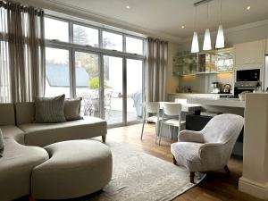 a living room with a couch and chairs and a kitchen at Tuishuisie in Stellenbosch