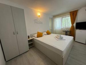 een slaapkamer met een groot bed met gele kussens bij Vila Yzabelle in Eforie Nord