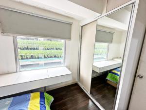 Cozy 2BR Apt with direct access to Mall @Green Bay Pluit Apartment في جاكرتا: غرفة بها مرآة وسرير ونافذة