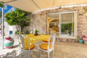 a yellow table and chairs on a patio at Paco's Resort Luxury Villa 32 in Oziás