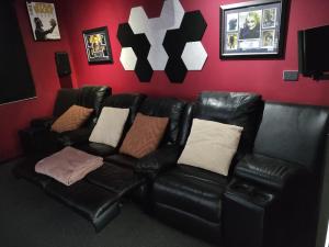 sala de estar con sofá de cuero negro con almohadas en Dream Clyde Family Home Movie Theater and Pool Table, en Clyde