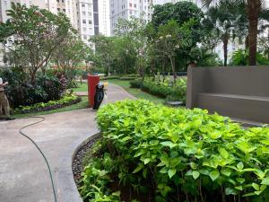 Cozy 2BR Apt with direct access to Mall @Green Bay Pluit Apartment في جاكرتا: حديقة فيها تمثال لقطة بجانب النباتات
