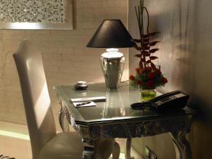 a table with a lamp and a phone on it at Hotel Grand regus in Bangalore +2 photos