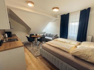 a bedroom with a bed and a kitchen and a table at Apartmány Javorná in Čachrov