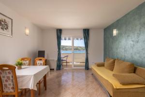 a living room with a couch and a table at Family Resort Santa Maria in Stara Novalja