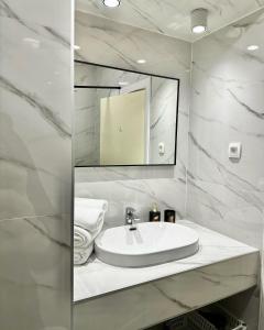 un bagno bianco con lavandino e specchio di Crolivia Apartments near Arena, center of Pula a Pola (Pula)