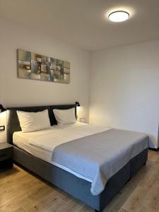 una camera da letto con un letto grande con lenzuola bianche di Crolivia Apartments near Arena, center of Pula a Pola (Pula) Altre 10 foto