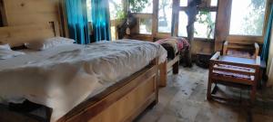 a bedroom with two beds and two windows at Parasharalya luxury home stay in Prashar lake