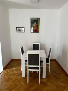 Biały stół i krzesła w pokoju w obiekcie City apartment with the sea view w Barze
