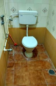 a bathroom with a toilet in a tiled floor at Sri bagavan lodge in Tiruvannāmalai