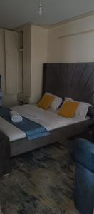a bedroom with a large bed with a wooden headboard at Attic place South B. in Nairobi