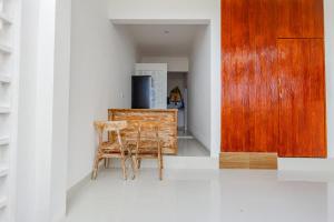 uma cozinha com 2 cadeiras e uma porta de madeira em Belvilla 93868 Hii Inn em Uluwatu