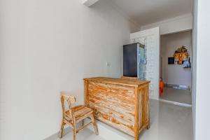 a wooden cabinet and a chair in a room at Belvilla 93868 Hii Inn in Uluwatu