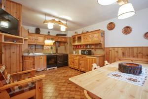 una grande cucina con armadi in legno e un tavolo in legno di Lioda Wood a Cibiana